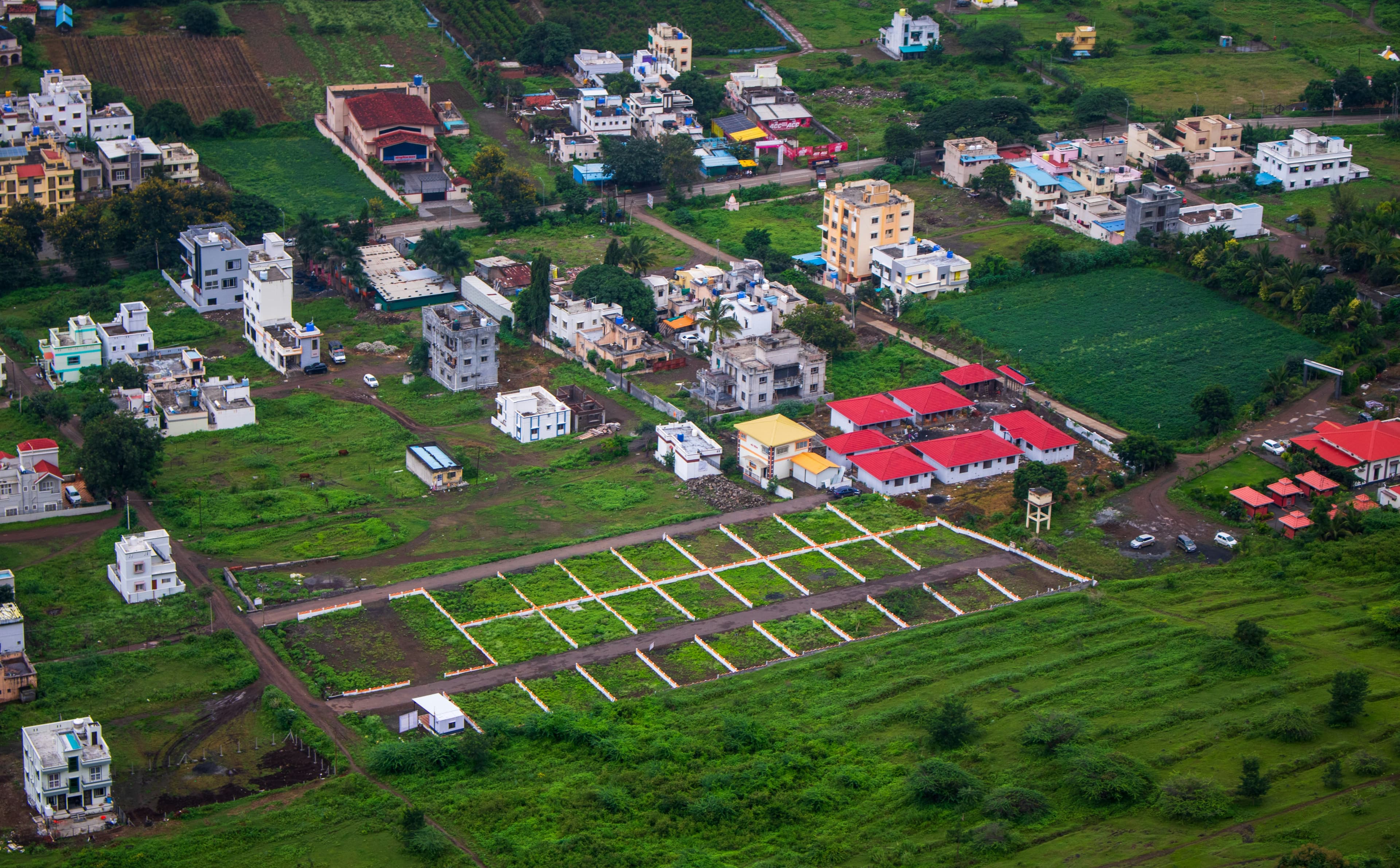 Aerial view of an Indian residential layout with demarcated plots